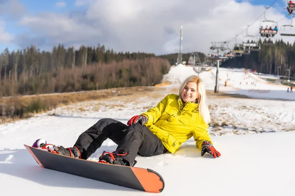 Fiatal nő kezében snowboard téli üdülőhelyen — Stock Fotó