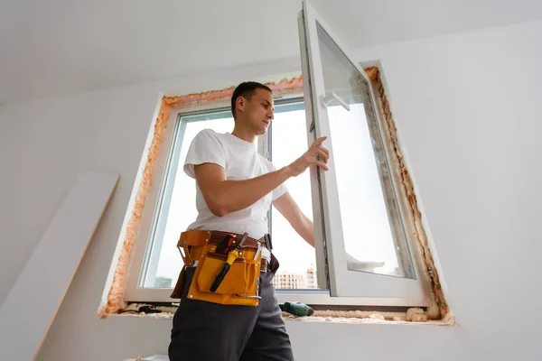 Trabajador constructor industrial masculino en la instalación de ventanas en el sitio de construcción de edificios —  Fotos de Stock