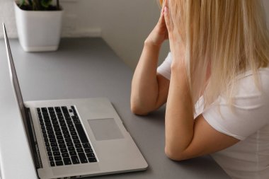 Baş ağrısı çeken bir kadın. Elleri şakakta. Boşluğu kopyala