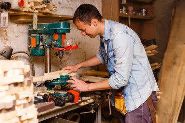 Marangoz antika mobilya üretimi için bir atölyede çalışıyor.