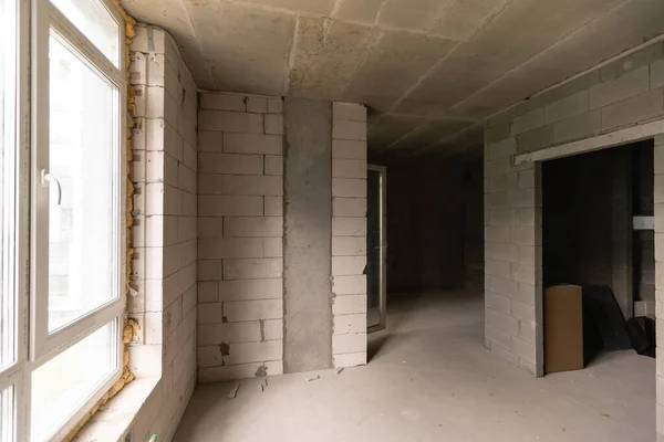 Petit appartement sans réparation dans un immeuble neuf. Une chambre dans une maison inachevée. Murs de bloc de mousse et plancher de béton dans un minuscule appartement. — Photo