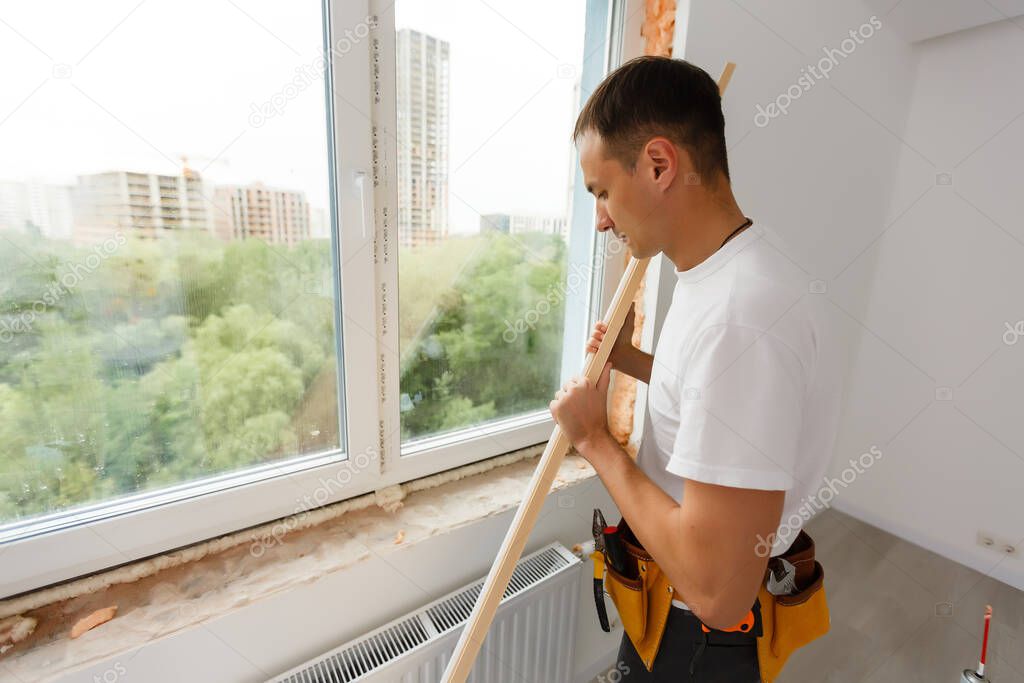 male industrial builder worker at window installation in building construction site