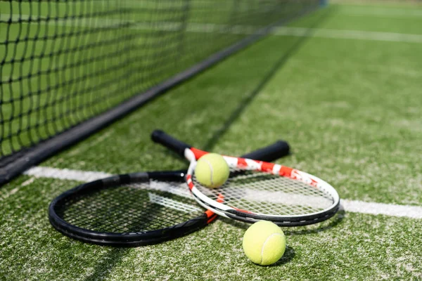 Una raqueta de tenis y una nueva pelota de tenis en una pista de tenis recién pintada — Foto de Stock
