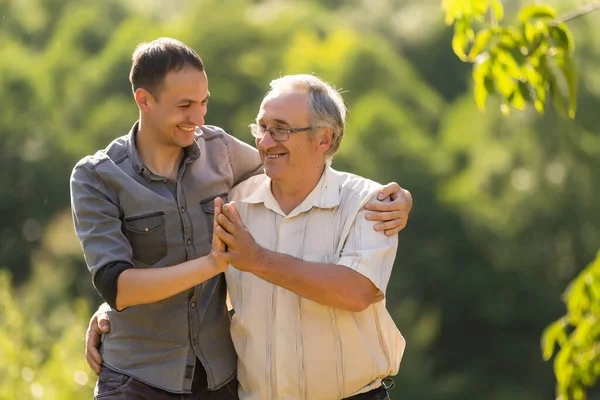 Vater und Sohn blicken im Garten in die Kamera — Stockfoto