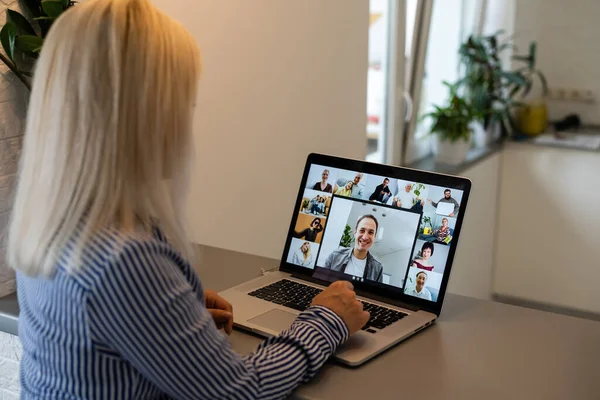 Back view of business woman talking to her colleagues about plan in video conference. Multiethnic business team using laptop for a online meeting in video call. Group of people smart working from home — Stock Photo, Image