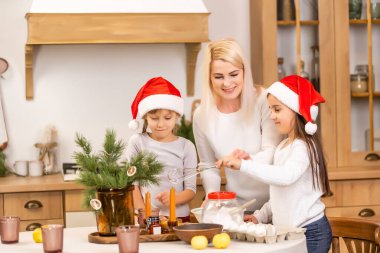 Çocuklar Noel kutlamasından önce Noel kurabiyesi pişiriyorlar. Aile