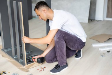 Evde mobilya montajı yapan yakışıklı adam..