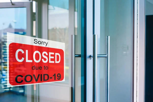 Centro de negocios cerrado debido a COVID-19, firmar con lo siento en la ventana de la puerta. Tiendas, restaurantes, oficinas, otros lugares públicos cerrados temporalmente durante la pandemia de coronavirus. Economía golpeada por el virus corona — Foto de Stock