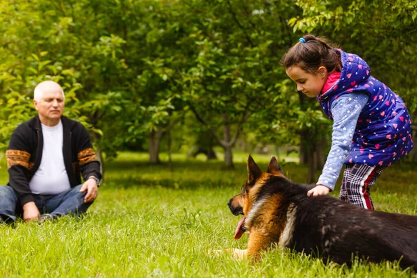 Abuelo con nieta y un perro en el jardín — Foto de Stock