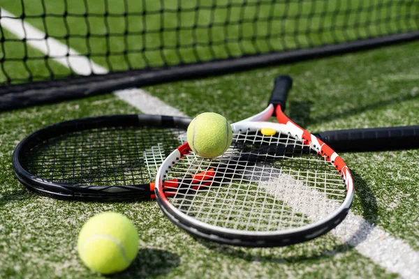 Tennisracket en nieuwe tennisbal op een pas geverfde tennisbaan — Stockfoto