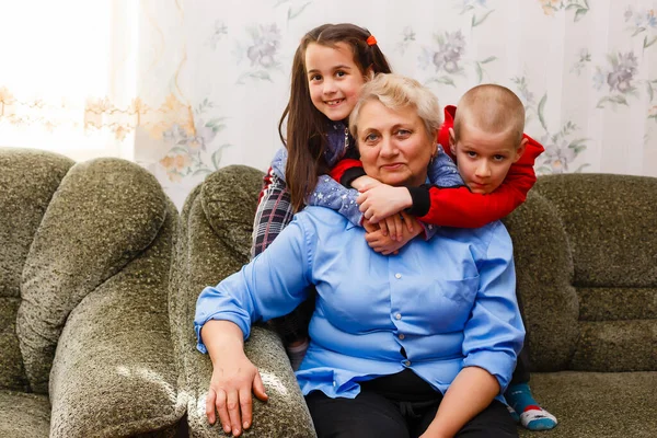 Grandir adulte souriant petits-enfants embrasse grand-mère âgée heureux de voir manquer elle, visite de parents aimants profiter de la communication, câlin comme symbole de connexion, l'amour et le concept de soutien — Photo