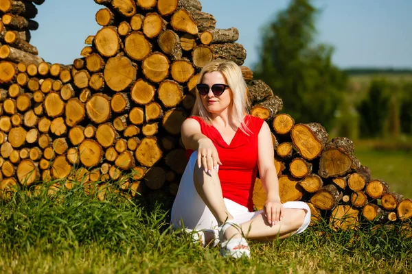 Frau sitzt im Park im Gras gegen Baum — Stockfoto