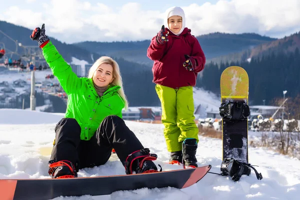 Mère et fille avec des snowboards jouent dans la neige — Photo