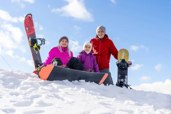 Сім'я зі сноубордами на зимовому курорті — стокове фото