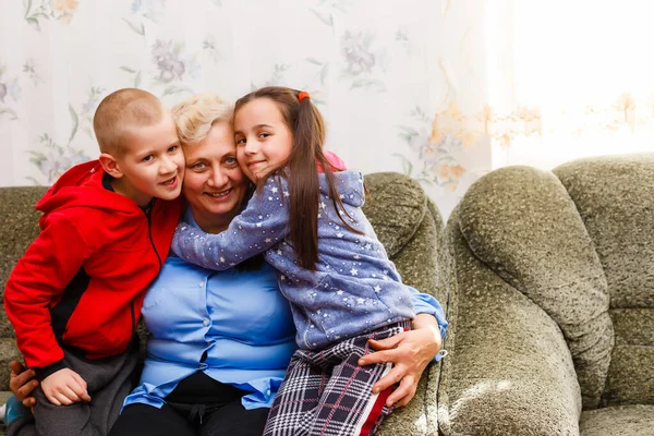 Grandir adulte souriant petits-enfants embrasse grand-mère âgée heureux de voir manquer elle, visite de parents aimants profiter de la communication, câlin comme symbole de connexion, l'amour et le concept de soutien — Photo