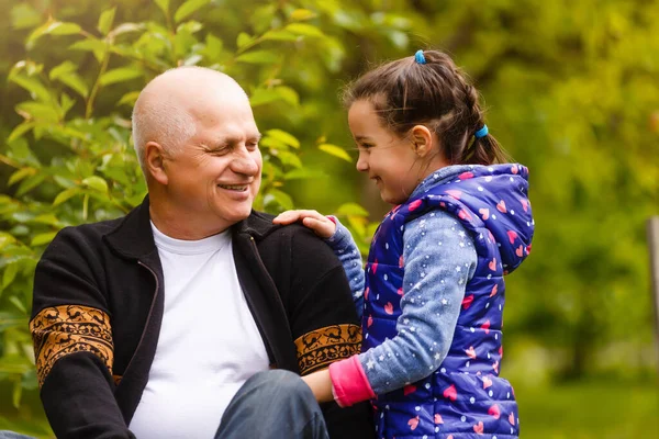 Portrait of small girl with senior grandfather in the backyard garden, standing. — Stock Photo, Image