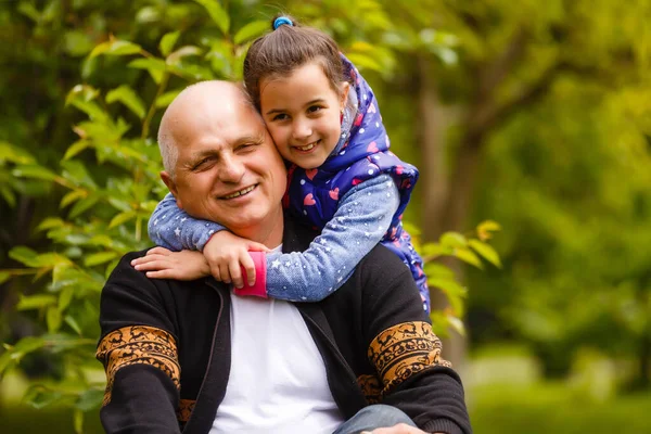 Beautiful granddaughter visiting her elderly kind grandfather. — Stock Photo, Image