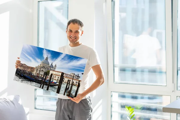 Mann hält Fotoleinwand zu Hause — Stockfoto