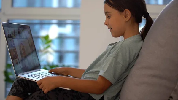 Schattig klein meisje met laptop thuis. Onderwijs, online studie, thuis studeren, afstandsonderwijs, schoolmeisje kinderen levensstijl concept — Stockfoto