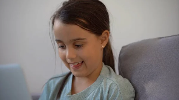 Linda niña usando el portátil en casa. Educación, estudio en línea, estudio en el hogar, aprendizaje a distancia, concepto de estilo de vida de escolares — Foto de Stock