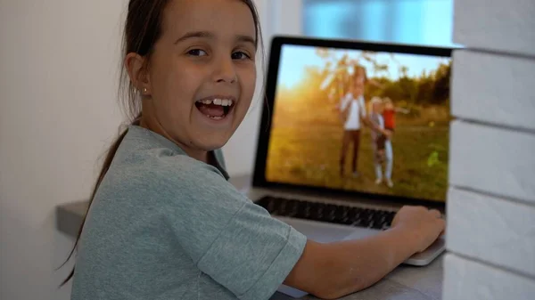 Bambina che guarda una foto in un computer portatile — Foto Stock