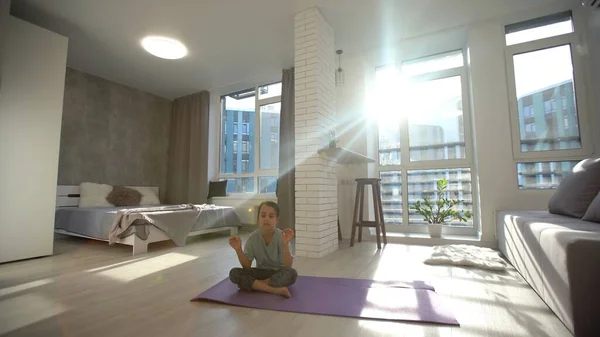 Menina bonito fazer um ioga em casa com espaço para adicionar texto — Fotografia de Stock