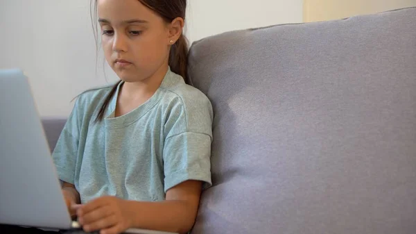 Menina bonito usando laptop em casa. Educação, estudo on-line, estudo em casa, educação a distância, conceito de estilo de vida de crianças colegiais — Fotografia de Stock