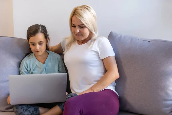 Bella donna che aiuta sua figlia a fare i compiti a casa — Foto Stock