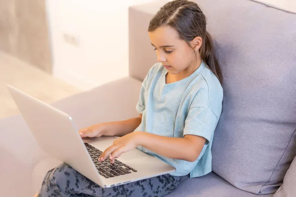 Menina fazendo seu dever de casa em casa e usando um laptop — Fotografia de Stock