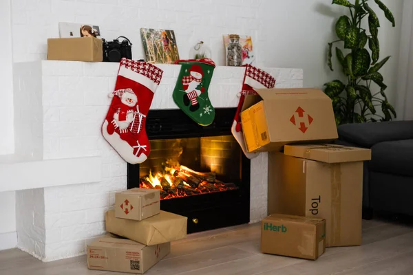 KYIV, UCRANIA - 16 de noviembre de 2020: cajas Nova Poshta con entrega de regalos de Navidad se encuentran cerca de la chimenea —  Fotos de Stock