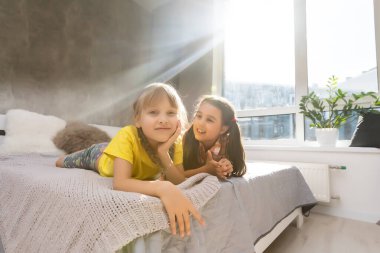 Küçük kız kardeşler birlikte yatakta.