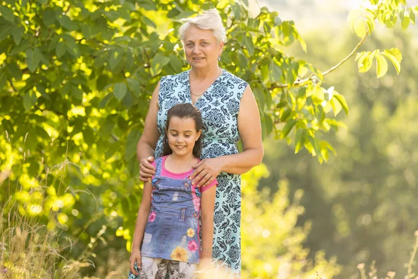 Gros plan portrait d'été de grand-mère heureuse avec petite-fille à l'extérieur. — Photo