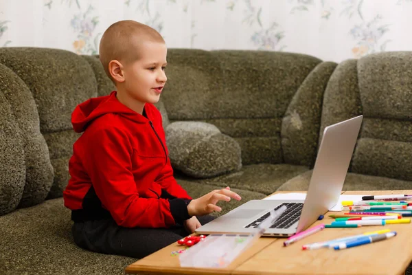 Felice ragazzo seduto alla sua scrivania con computer portatile — Foto Stock