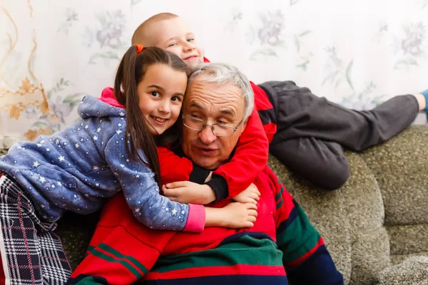 Grandfather spends time with grandchildren in the living room — Stock Photo, Image