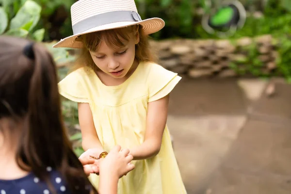 Мила маленька дівчинка тримає живий красивий метелик на руці — стокове фото