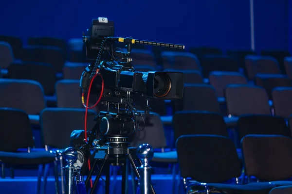 プロのビデオカメラ、ビデオカメラ、青の背景にカメラの黒いシルエット、クローズアップ — ストック写真