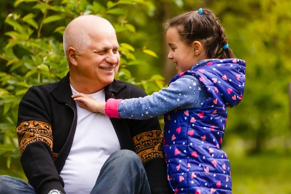 Little girl spending time with grandfather in the park. — Stock Photo, Image