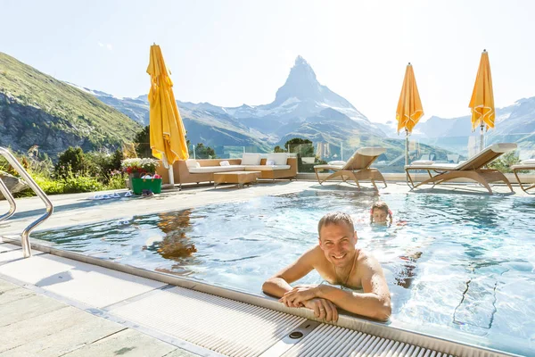 Giovane uomo che si rilassa su una terrazza aperta nella SPA con una montagna incredibile — Foto Stock