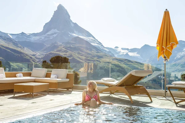 Donna che gode della vista panoramica dalla piscina nelle Alpi — Foto Stock