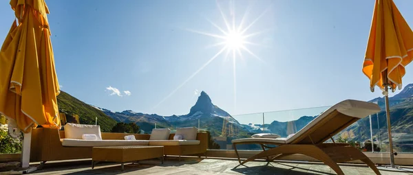 Bellissimo balcone con lettini e piante con splendida vista sulle montagne sullo sfondo e cielo blu — Foto Stock