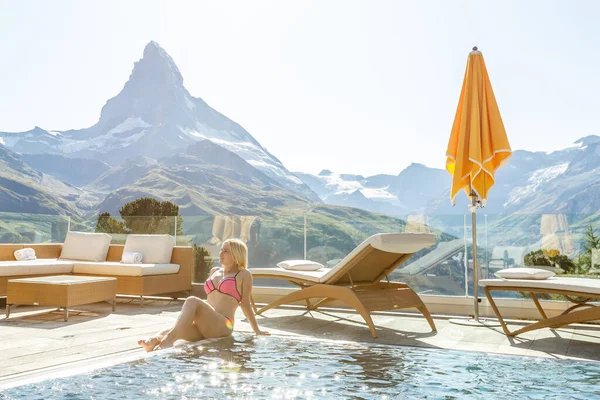 Vrouw die geniet van het panoramische uitzicht vanaf het zwembad in de Alpen — Stockfoto