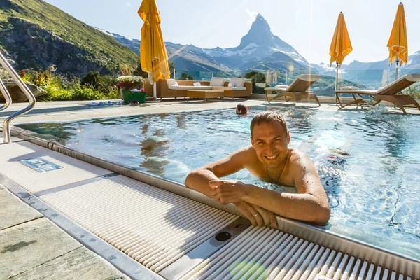 Giovane uomo che si rilassa su una terrazza aperta nella SPA con una montagna incredibile — Foto Stock