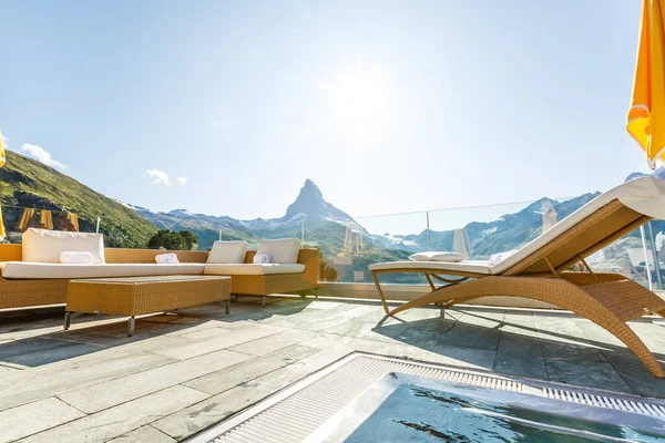 Bellissimo balcone con lettini e piante con splendida vista sulle montagne sullo sfondo e cielo blu — Foto Stock