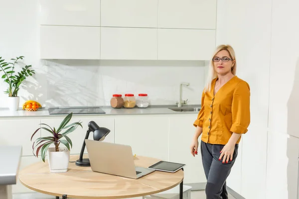 Portrait de femme travaillant avec un ordinateur portable dans une cuisine lumineuse. Coronavirus Covid-19. Distance sociale — Photo