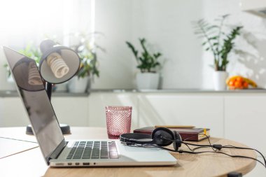 Modern mutfak odasındaki ahşap masada dizüstü bilgisayar..