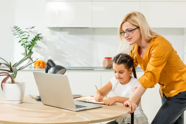 Coronavirus Outbreak. Lockdown and school closes. Mother helping daughter studying online classes at home. COVID-19 pandemic, children and teachers online learning. — Stock Photo, Image