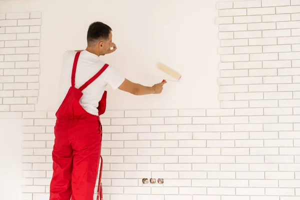 Чоловік малює стіну, майстер стінний живописець — стокове фото