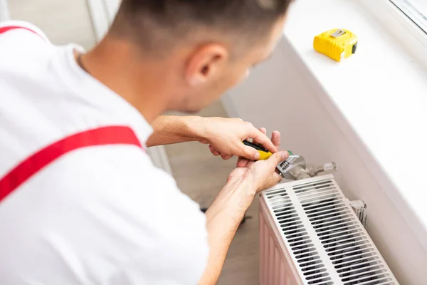 Primer plano de manos mecánicas maduras reparando el sistema de calefacción. — Foto de Stock