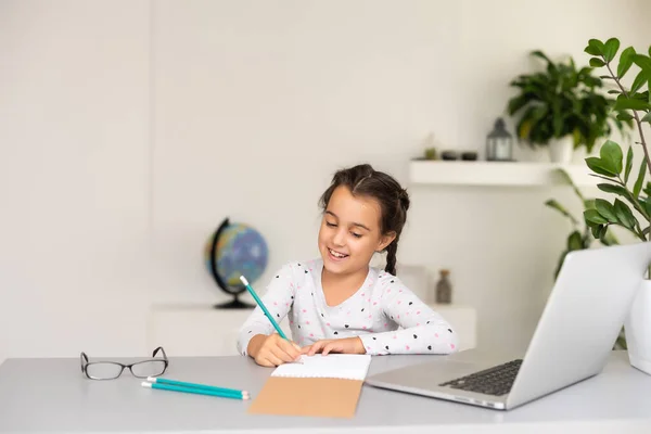 Ragazzina che studia online usando il suo portatile a casa — Foto Stock