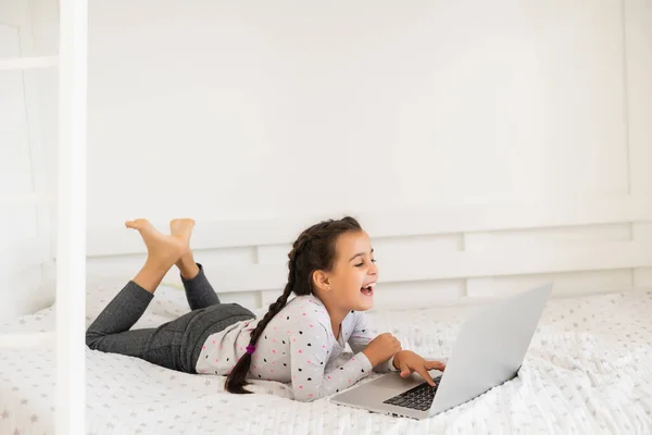 Ragazzina che studia online usando il suo portatile a casa — Foto Stock